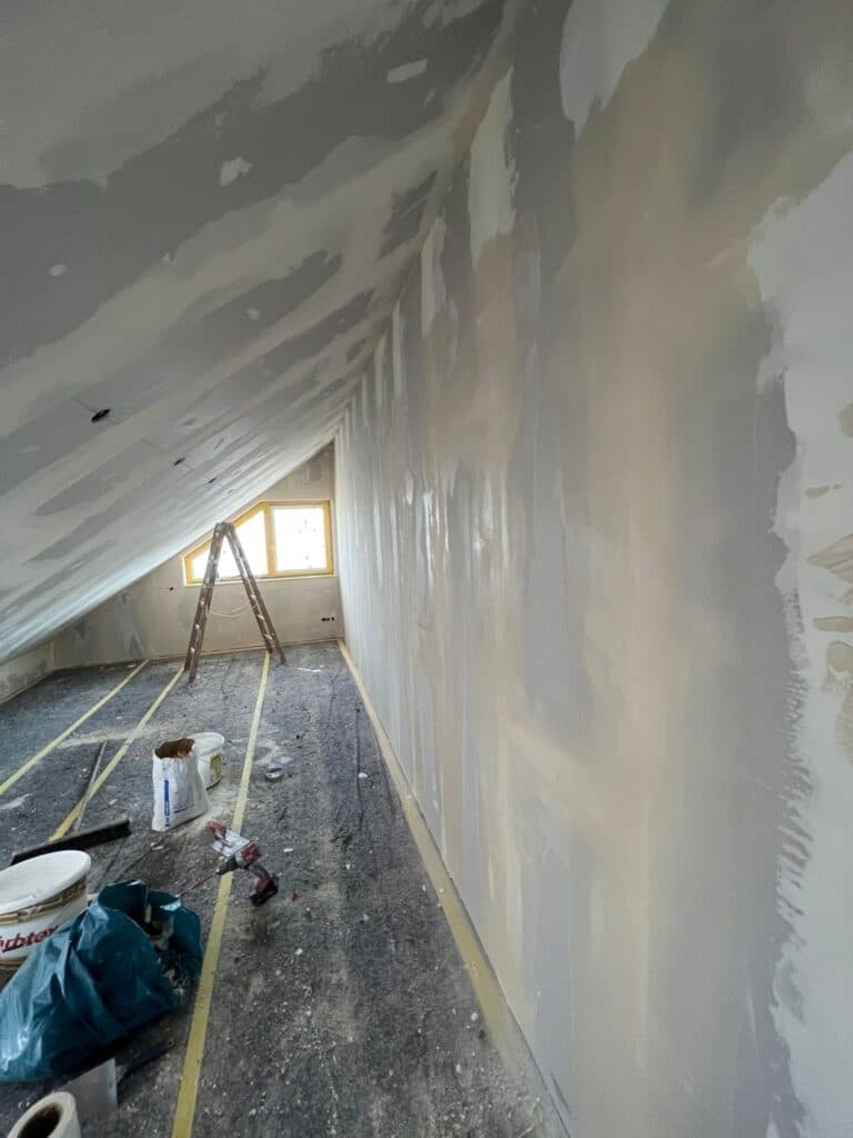 Ausgebautes Dachgeschoss mit beplankten und verspachtelten Dachschrägen, Tageslicht durch ein Dachfenster